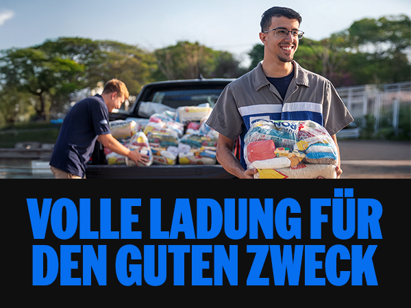 Zwei Personen laden Spenden in ein Auto, um Hilfe für den guten Zweck zu leisten. Freundliche Stimmung im Freien.